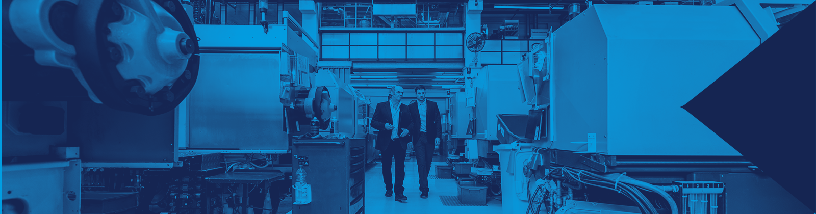 Two People Walking Through an Injection Molding Facility